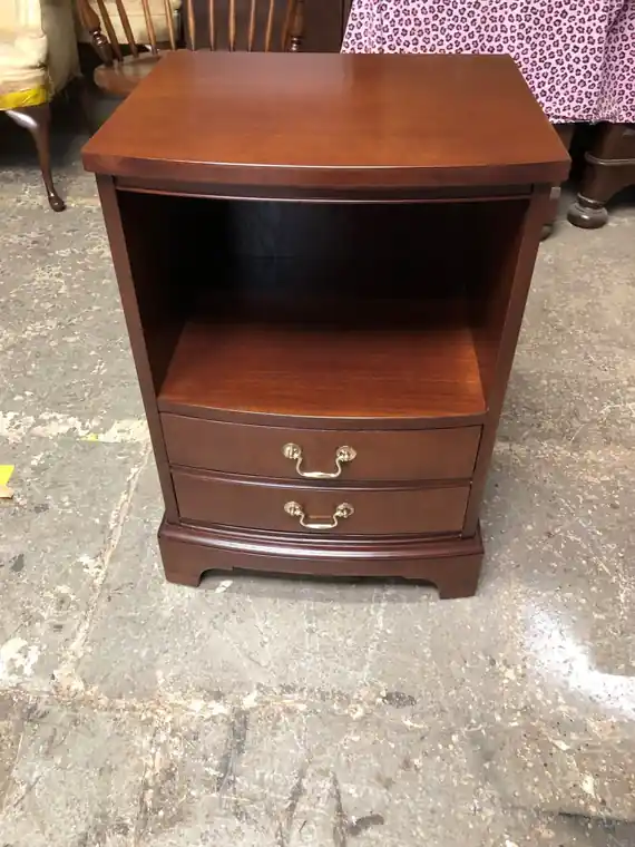 The same bedside table after refinishing, an even deep mahogany finish