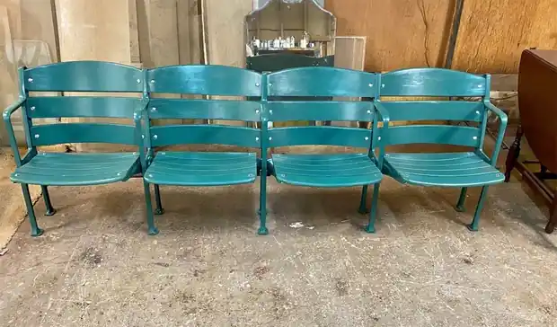 Stadium seating after restoration, a row of four seats painted teal
