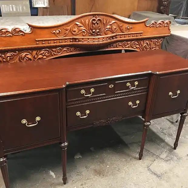Mahogany sideboard with a carved crest and brass pulls