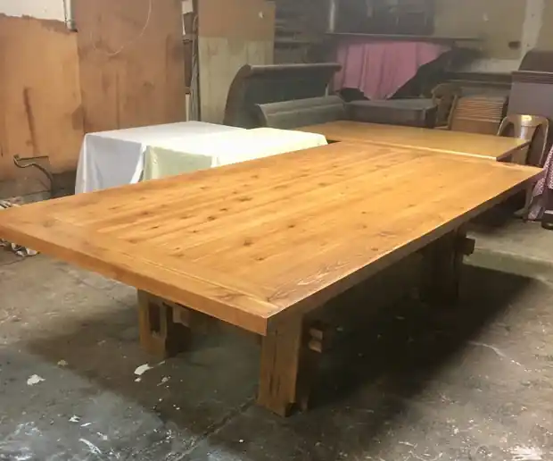 Long cedar plank table on the concrete shop floor
