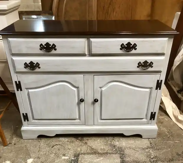Two-door buffet painted soft grey with a dark stained top and black hardware