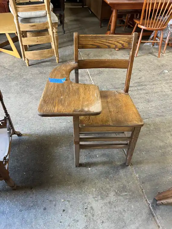 Refinished oak school chair with a curved back slat, standing on the shop floor