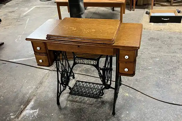 Oak treadle sewing table on its cast iron base