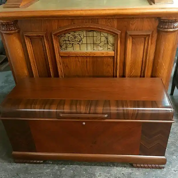 A waterfall-style cedar chest with striped veneer on the lid and chevron veneer on the front